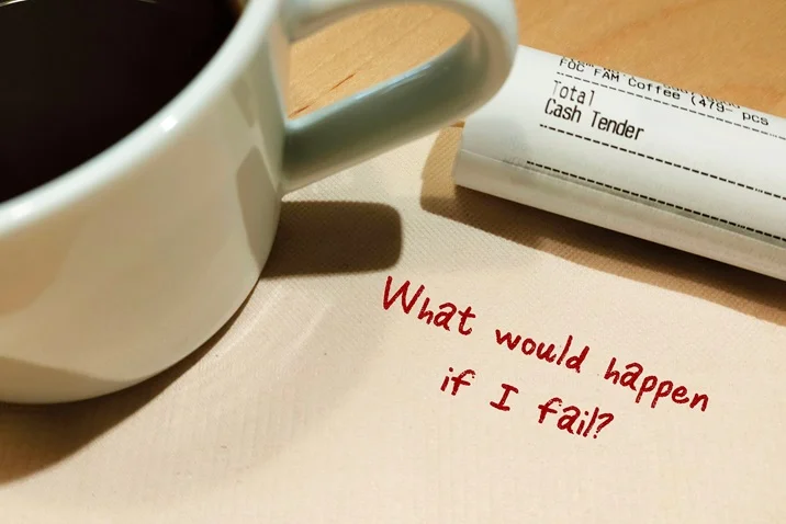 A torn paper with the words "What would happen if I fail?" highlighting fear of failure and self-doubt in imposter syndrome.